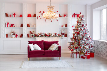 Interior of bright modern living room with fireplace, chandelier and comfortable sofa decorated with Christmas tree and red gifts