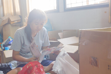 A woman cleaning and clearing unnecessary things out of her room.Natural flare include