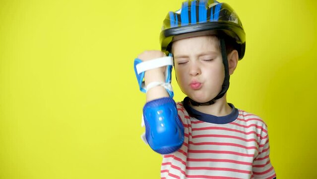A boy in a helmet, elbow pads and gloves - protection when riding a bicycle, skateboard.