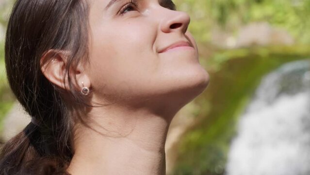 Meditation in nature. Beautiful young woman in mountains on sunny day, closeup. Camera moving up