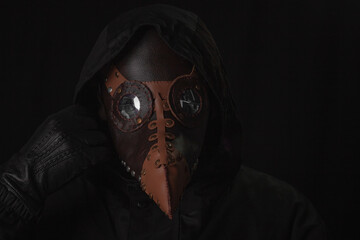 Dark horror figure in black hood in plague doctor mask