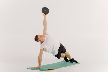 Athletic young man doing workouts at home, man doing training, warm up before weight exercise.