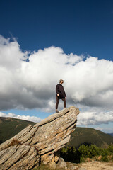 a young woman stands on top of a stone mountain