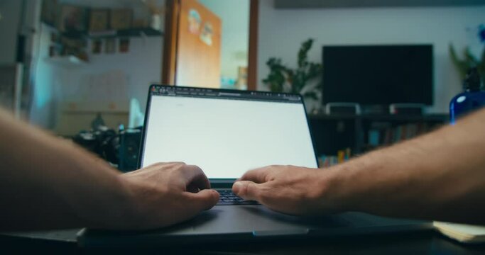 Freelance worker typing on computer keyboard in livingroom working home pov shot