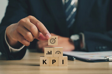 Key Performance Indicator (KPI). Businessmen arrange wood cubes with KPI icons. business goals,...