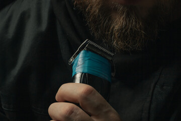 Naklejka premium shaving the beard with a broken clipper insulating tape