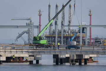 LNG TERMINAL - Workers and construction machinery on a gas terminal building site 
