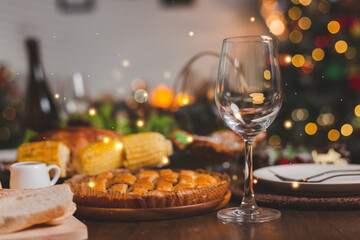 Traditional celebration. Roasted chicken, wine, vegetables salad and various food are set on table for family to celebrate together at night and Christmas tree set in the room for Christmas holiday.