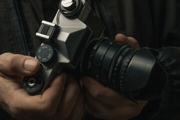 man holding Retro film photo camera isolated on black background soviet