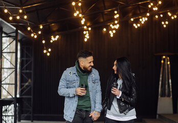 Fototapeta na wymiar Outdoor happy couple in love posing near cafe