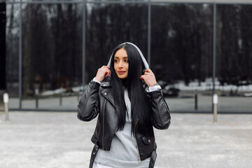 Young caucasian girl with dark long hair in sporty gray hoodie