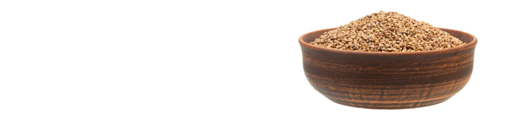 buckwheat in a clay bowl on a white background. the concept of a good harvest of buckwheat