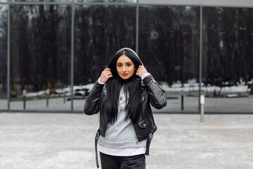 Fototapeta premium Young caucasian girl with dark long hair in sporty gray hoodie