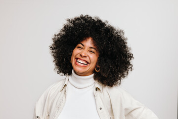 Happy young woman of color smiling at the camera in a studio