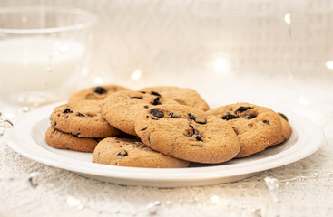 Cookies with chocolate chips close-up and glass of milk.