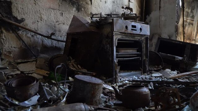 Bombed kitchen and things close-up. Consequences fire after a russian shellings. Left belongings of residents. Fire in the house. 