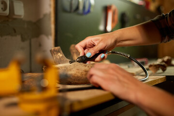Female using power wood working tools graver, carving while crafting