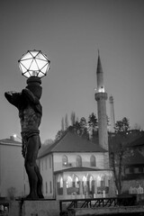 Vertikale Schwarz-Weiß-Aufnahme eines schönen Lampendesigns mit einer Skulptur auf der Straße