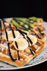 Close-up, Belgian waffles with fruits, covered with chocolate.