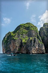 Aerial view of rock formations surrounded by water under blue bright sky