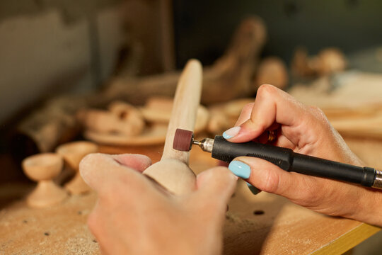 Female using power working tools graver for wooden utensils spoon