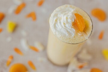 Selective focus high angle closeup of an Orange Coconut Shake on a marble surface