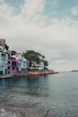 Naklejka premium Vertical shot similar houses near the stony beach on a clouded day