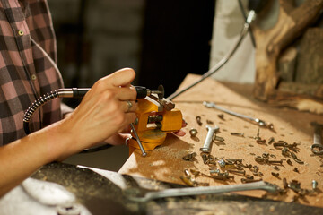Woman using power working grinder machine, female hand grinds a metal nuts