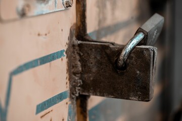 Selective focus of a rusty lock of the industrial machine with a blurry background