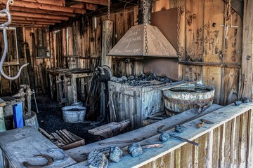 Blacksmith's workshop with a rusty chimney hood written on it "deaf blacksmith, please speak up"