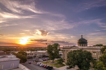 Architecture of Courthouse in Georgetown, Texas with street view, cars, greenery at sunset - obrazy, fototapety, plakaty