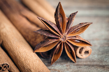 Star anise and cinnamon sticks close-up on a wooden background.