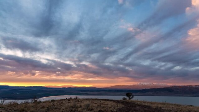 Colorful sunset timelapse over the landscape in Utah viewing Utah Lake from the top of West Mountain.
