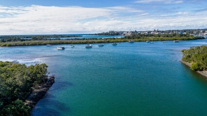 Aerial view of boats and ships in Hastings River and lush green forests in Port Macquarie, Australia