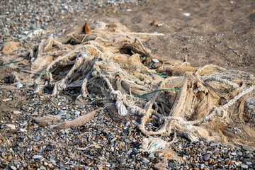 Old torn fishing nets on the seashore.