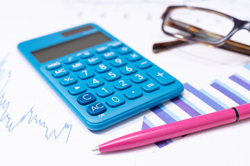 Business financial report background. Calculator, pen, eyeglasses and charts on work desk