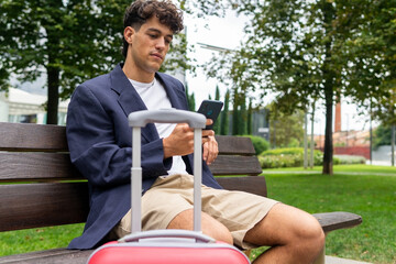 Relaxed male using smartphone on bench