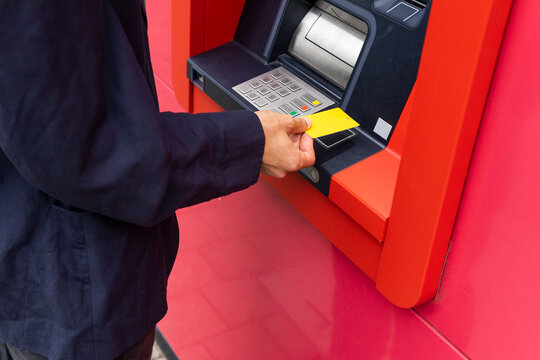 Crop man using ATM on street