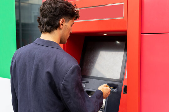 Crop man using ATM on street