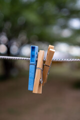 3 clothespins, one blue and 2 wooden