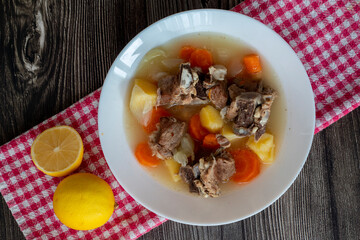 Boiled lamb meat with potatoes, carrots , onions, top view, copy space. Homemade winter comfort food.