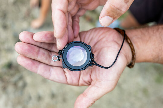 Crop man demonstrating magnifier on hand