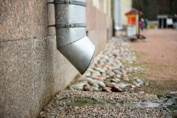Downpipe close-up in the city on a building during the rain