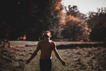 Fototapeta na wymiar Spanish man with open arms shirtless looking upwards in a forest