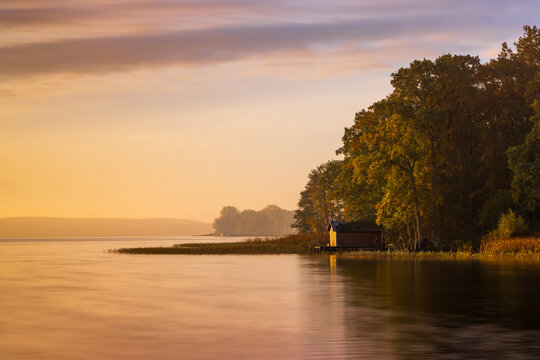 Einsames Bootshaus am Ufer des Plauer Sees in der Mecklenburgischen Seenplatte im Herbst zu Sonnenaufgang