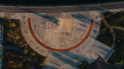 Top view of a zodiac sundial on the ground with palm trees around in Figueira da Foz, Portugal