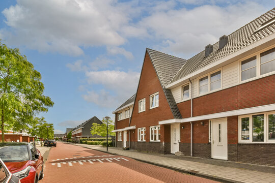 Street With Houses Lined Up Next To Parked Cars