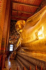 Vertikale Aufnahme des goldenen liegenden Buddha im Tempel Wat Pho in Bangkok