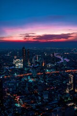 Fototapeta premium Vertical shot of the cityscape of Bangkok city in Thailand under the purple sunset sky