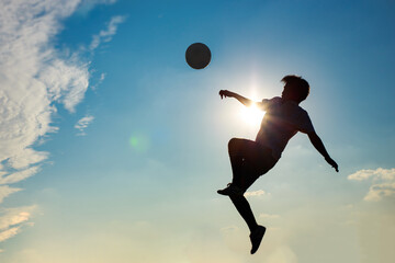 Fototapeta na wymiar Silhouette action sport outdoors of football players on the sunset sky. Athlete man jumping kick soccer ball for world cup tournament background concept.